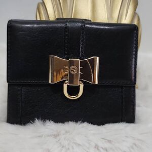 Gucci leather wallet featuring a distinct gold-toned bow clasp